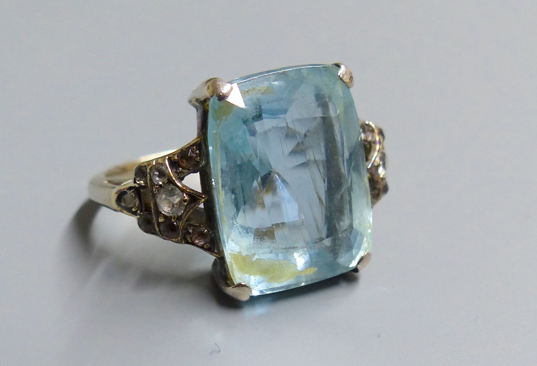 An early 20th century yellow metal, aquamarine and white stone chip set dress ring, size J, gross 5.2 grams.